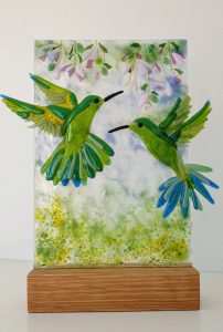 Hummingbirds drinking from flowers, hand fused glass art - by Morvern Glass